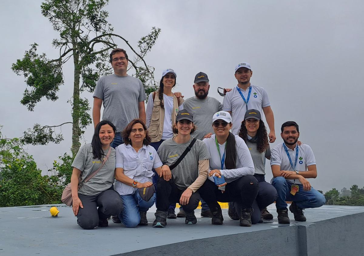Los equipos de Ferrovial y Acción contra el Hambre posan juntos sobre el depósito de agua en La Cuchilla, Colombia.