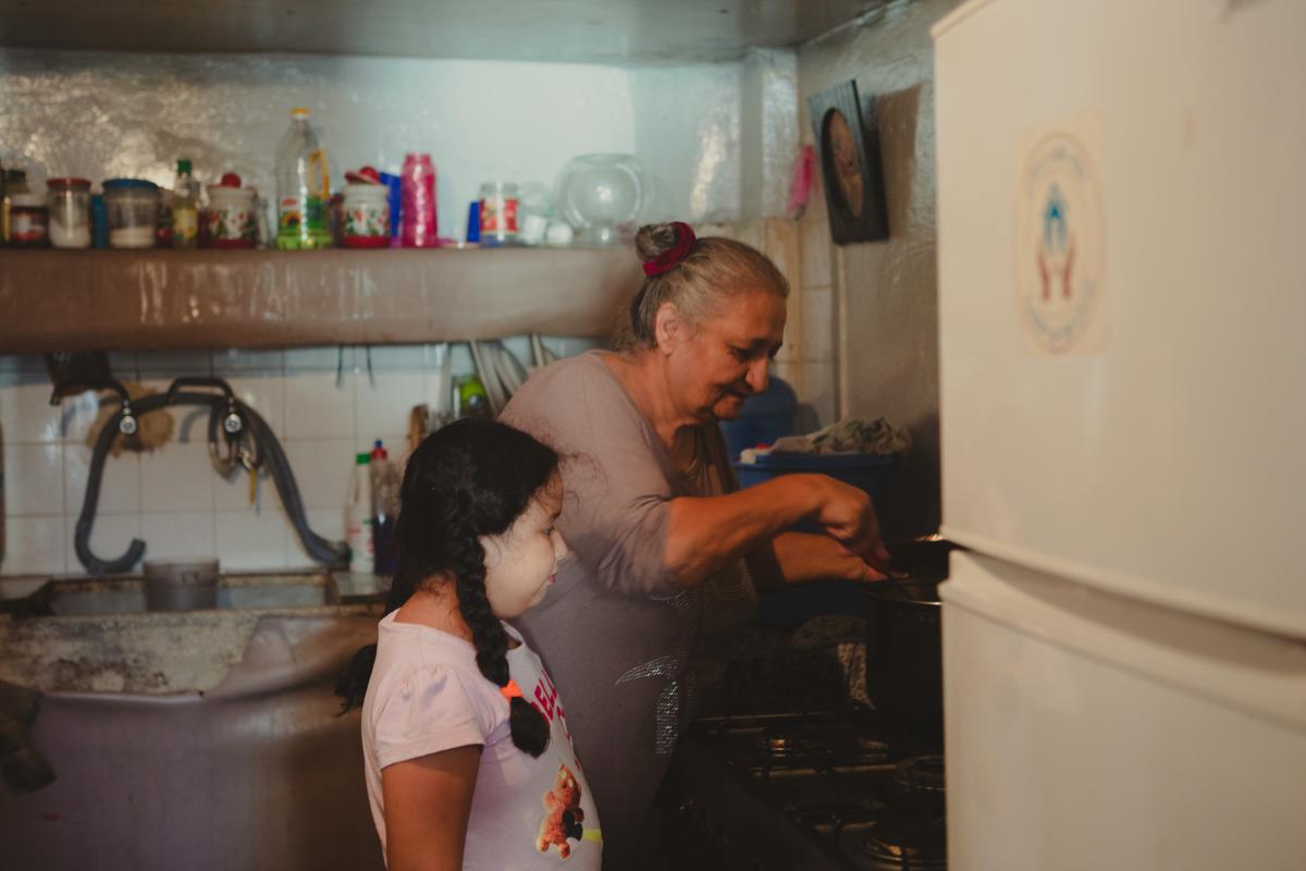Una mujer libanesa vulnerable, beneficiaria de los programas de ayuda en efectivo de Acción contra el Hambre, cocinando junto a su nieta en Beirut
