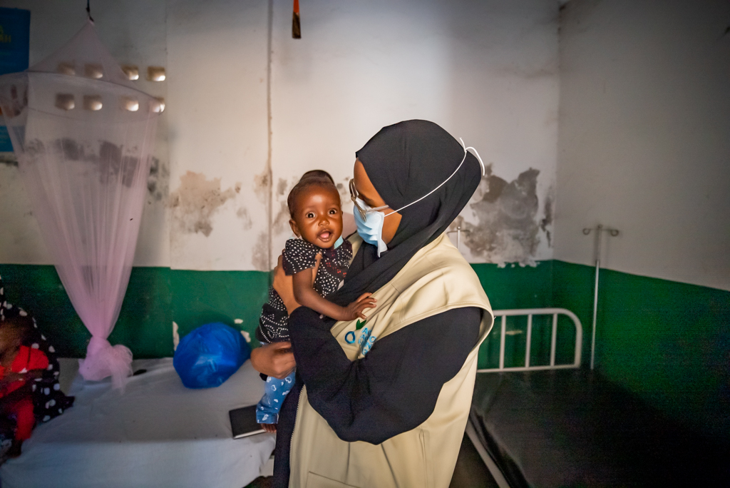 Mujer cuidando un niño en un centro de atención de Acción contra el Hambre en Somalia