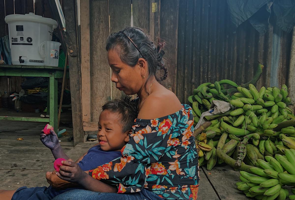Madre jugando con su hijo en su vivienda duran te una visita comunitaria. Amazonas, Colombia © Acción contra el Hambre.