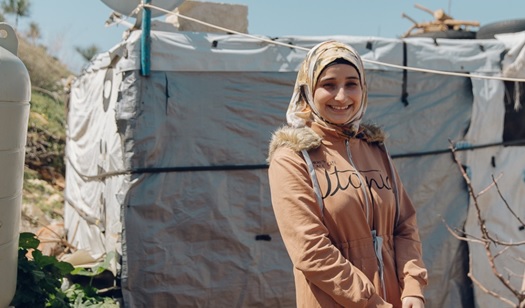 Douaa in front of her tent where she lives with her parents and siblings.