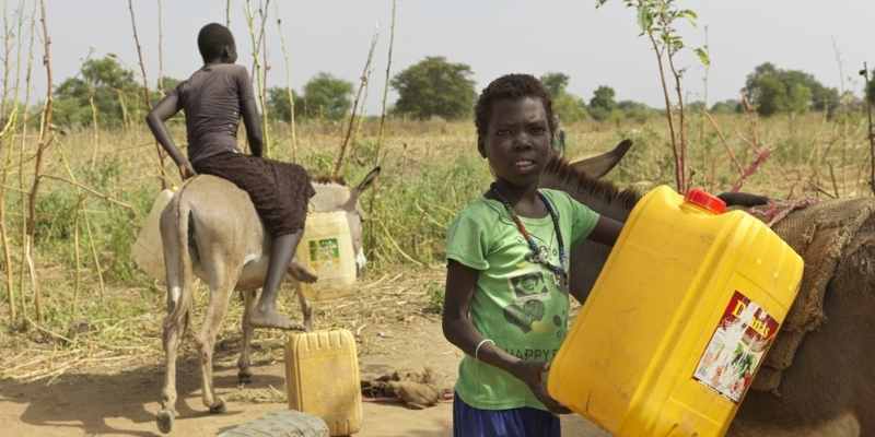 Uno de los hijos de Nyanut, Amiok Piol, de 7 años, se prepara para recoger agua del pozo.