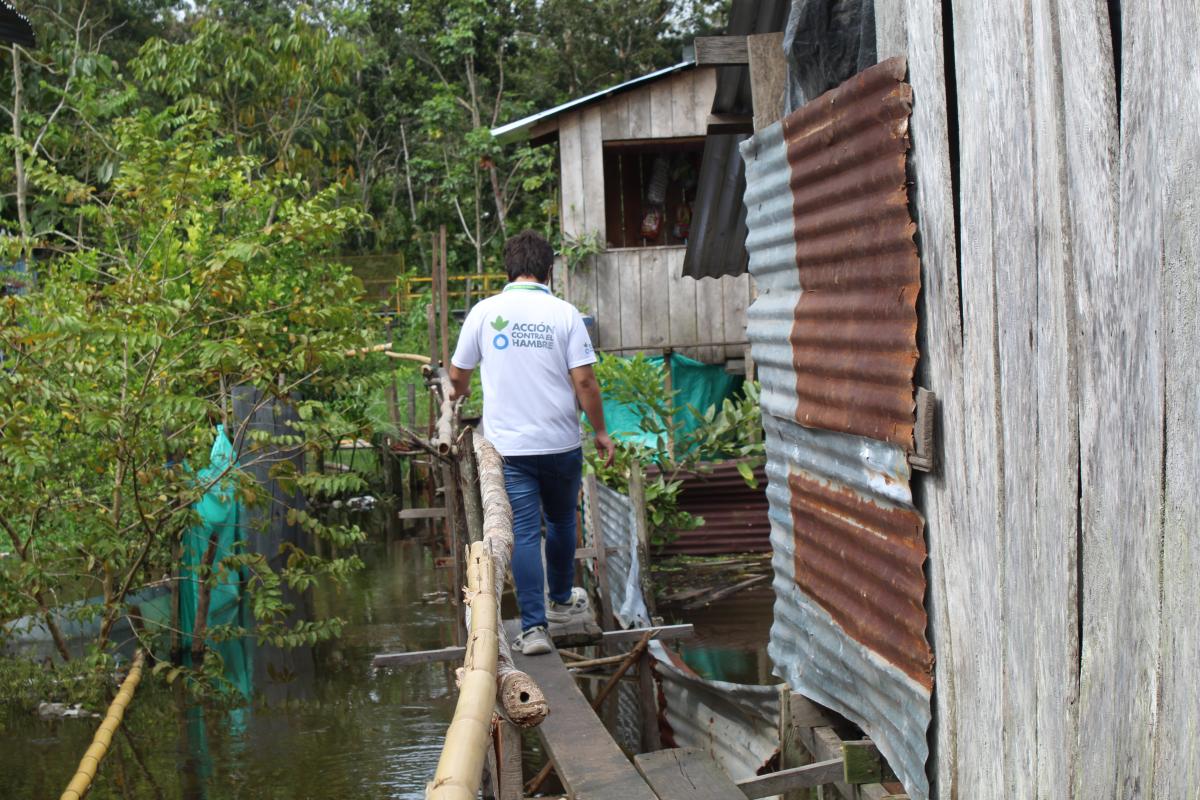 Personal de Acción contra el Hambre cruzado un puente de madera para llegar a la vivienda de una familia con difícil acceso, durante una visita comunitaria, Colombia © Acción contra el Hambre.