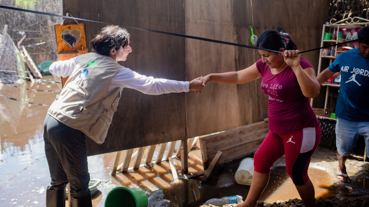 Trabajadora humanitario dando la mano a Rosa, damnificada por las inundaciones en Piura, Perú. © Acción Contra el Hambre