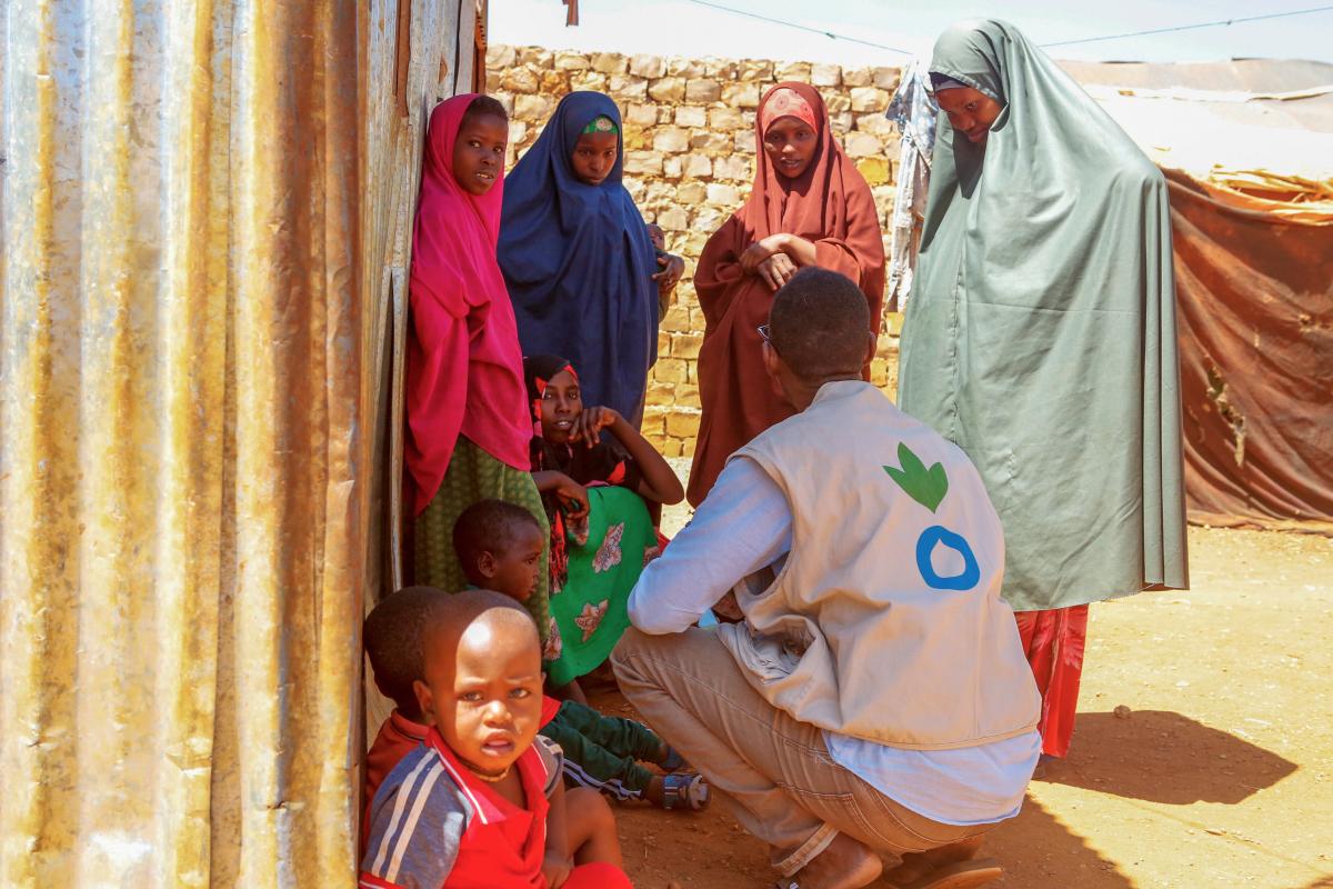 Un miembro del personal de Acción contra el Hambre ayuda a las personas obligadas a abandonar sus hogares en un campamento improvisado en Somalia. Crédito de la foto: Acción contra el Hambre / Ahmed Issak Hussein