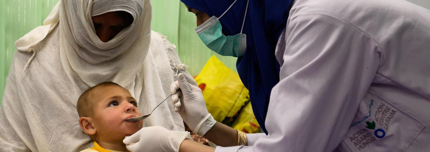 Una enfermera administra suspensión oral a un niño de 2 años que sufre desnutrición