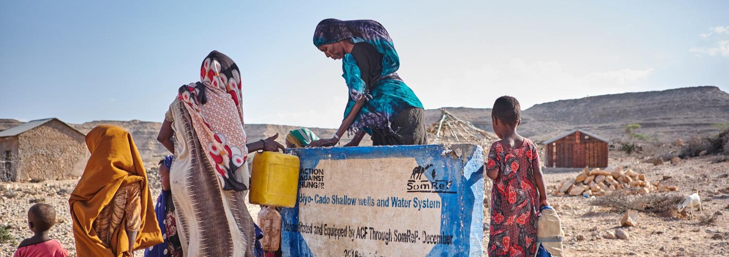 mujeres cogen agua de una fuente en Somalia