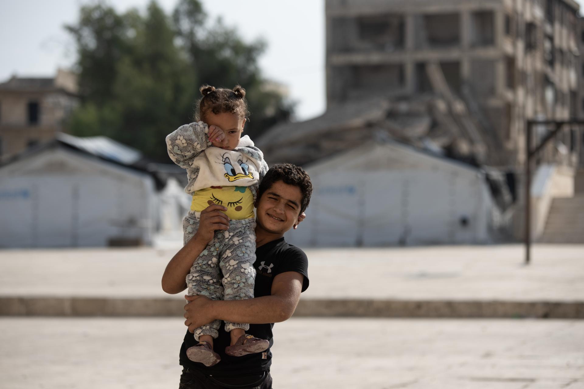 dos niños juegan en el patio de un colegio que se usa como refugio para los desplazados por el terremoto del norte de Siria