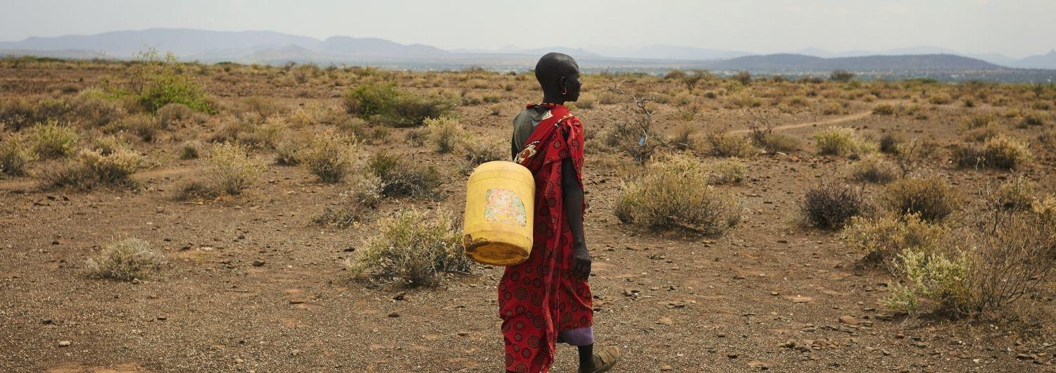 Una mujer va a rellenar bidones de agua de 15 litros en un agujero donde, entre dos rocas, se estanca agua no potable y llena de bacterias.