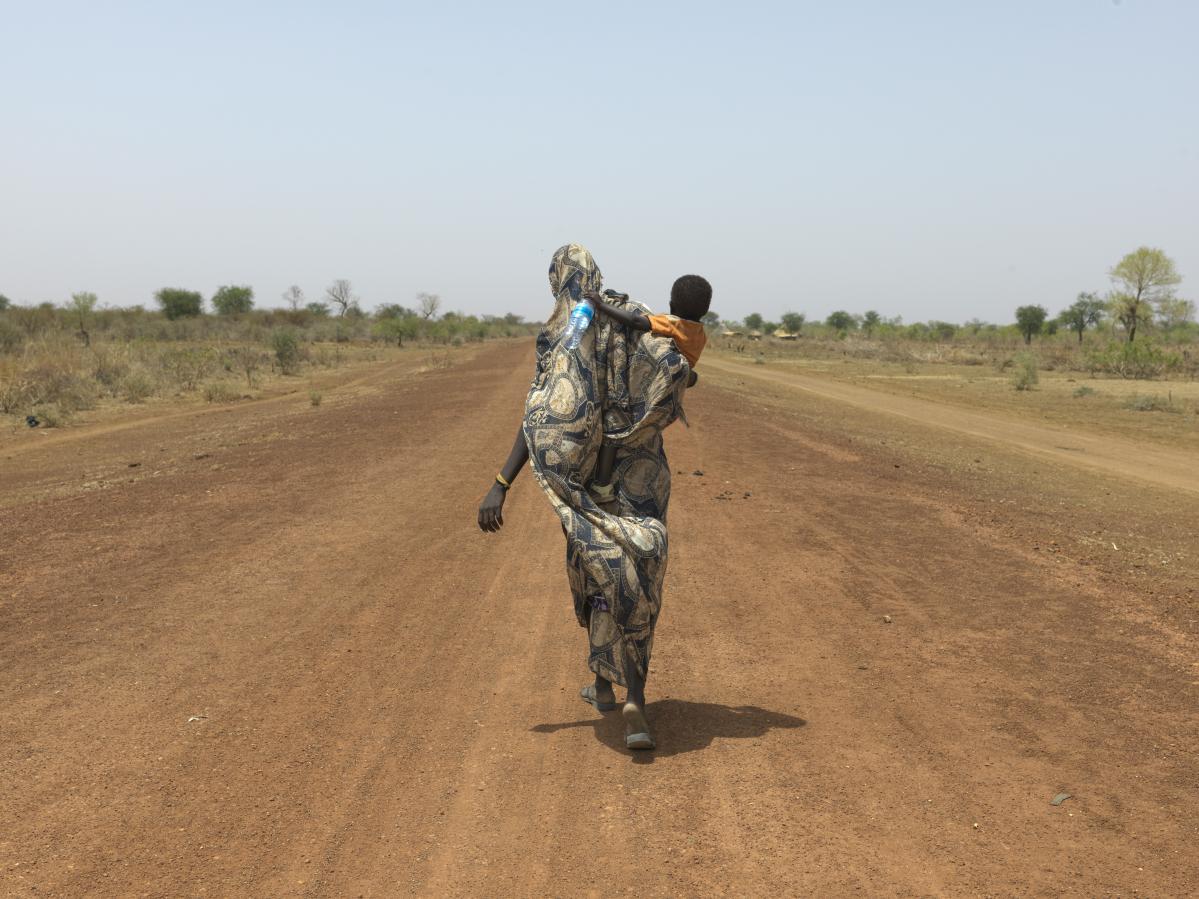 Nyibol Mathiang Deng, de 27 años, está embarazada de seis meses y llegó a la frontera con su hija menor.